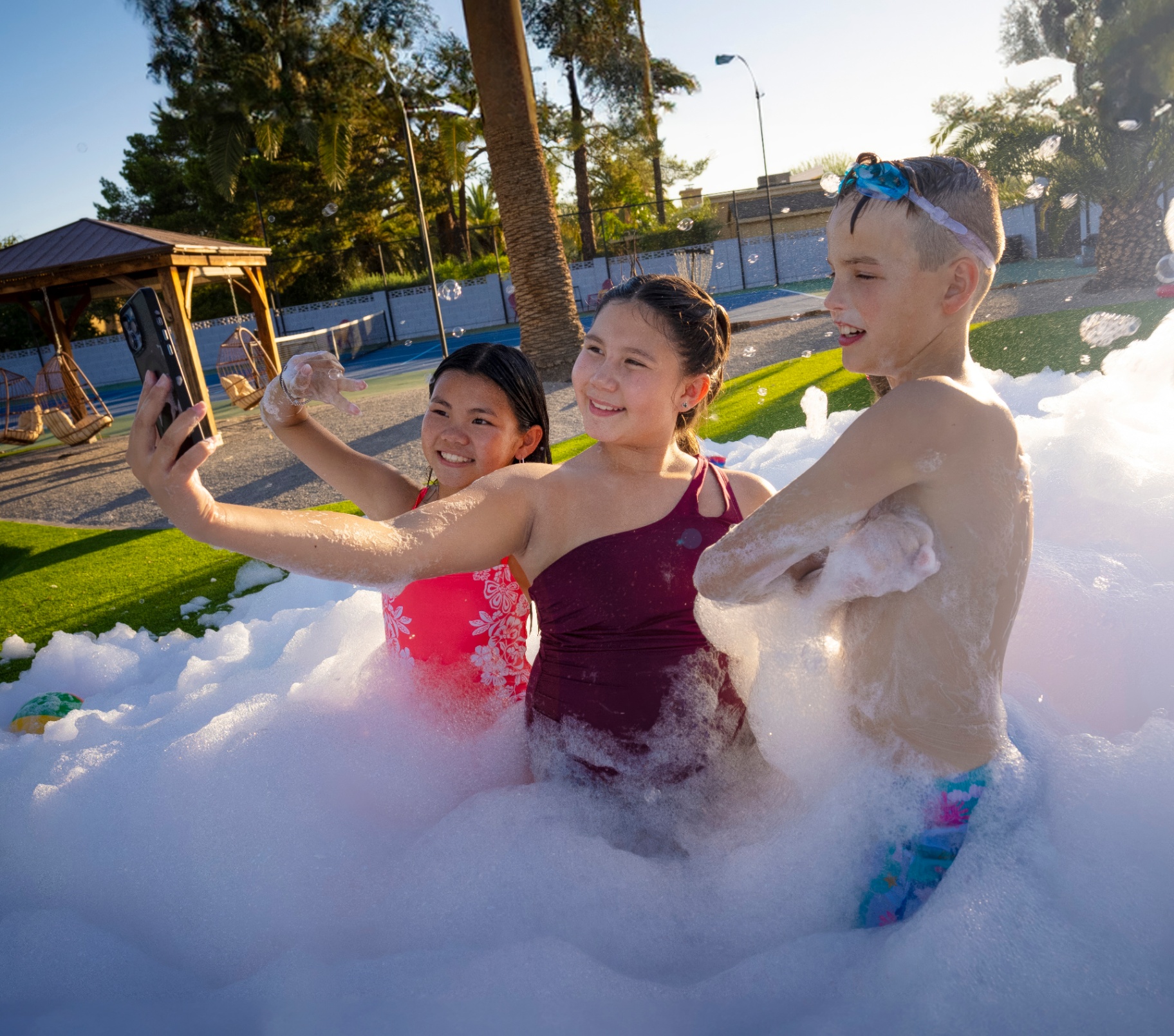 Three kids taking a selfie in a foam party