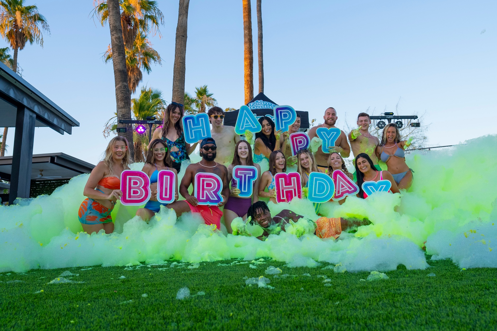 Group celebrating a Happy Birthday foam party outdoors